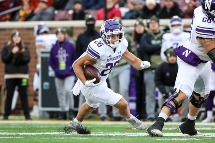 Nov 12, 2022; Minneapolis, Minnesota, USA; Northwestern Wildcats running back Evan Hull (26) runs the ball against the Minnesota Golden Gophers during the first quarter at Huntington Bank Stadium. Mandatory Credit: Matt Krohn-USA TODAY Sports